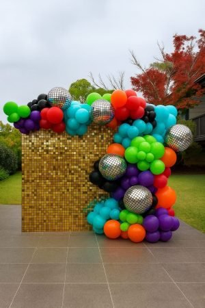 Gold shimmer wall backdrop with balloon garland for party hire in Sydney